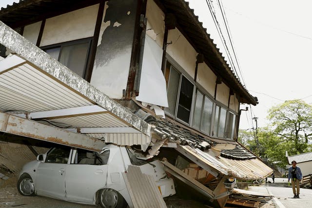 An earthquake-damaged house and car caused in Mashiki