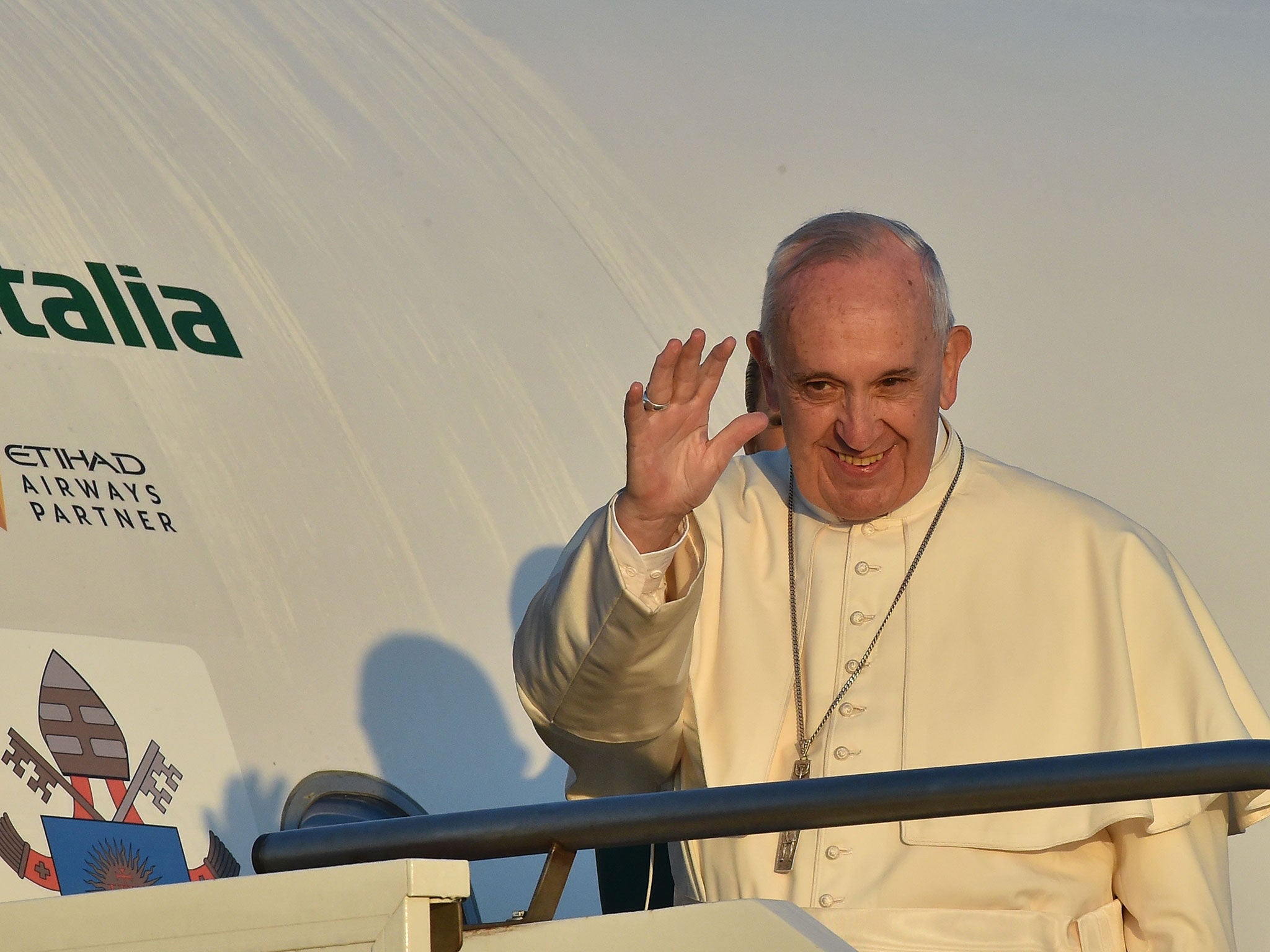 Pope Francis waves to journalists as he boards an plane at Rome's Fiumicino airport, on his way to the Greek island of Lesbos