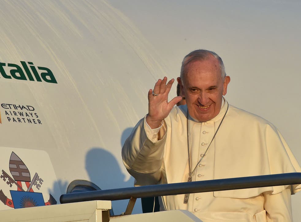 Pope Francis waves to journalists as he boards an plane at Rome's Fiumicino airport, on his way to the Greek island of Lesbos
