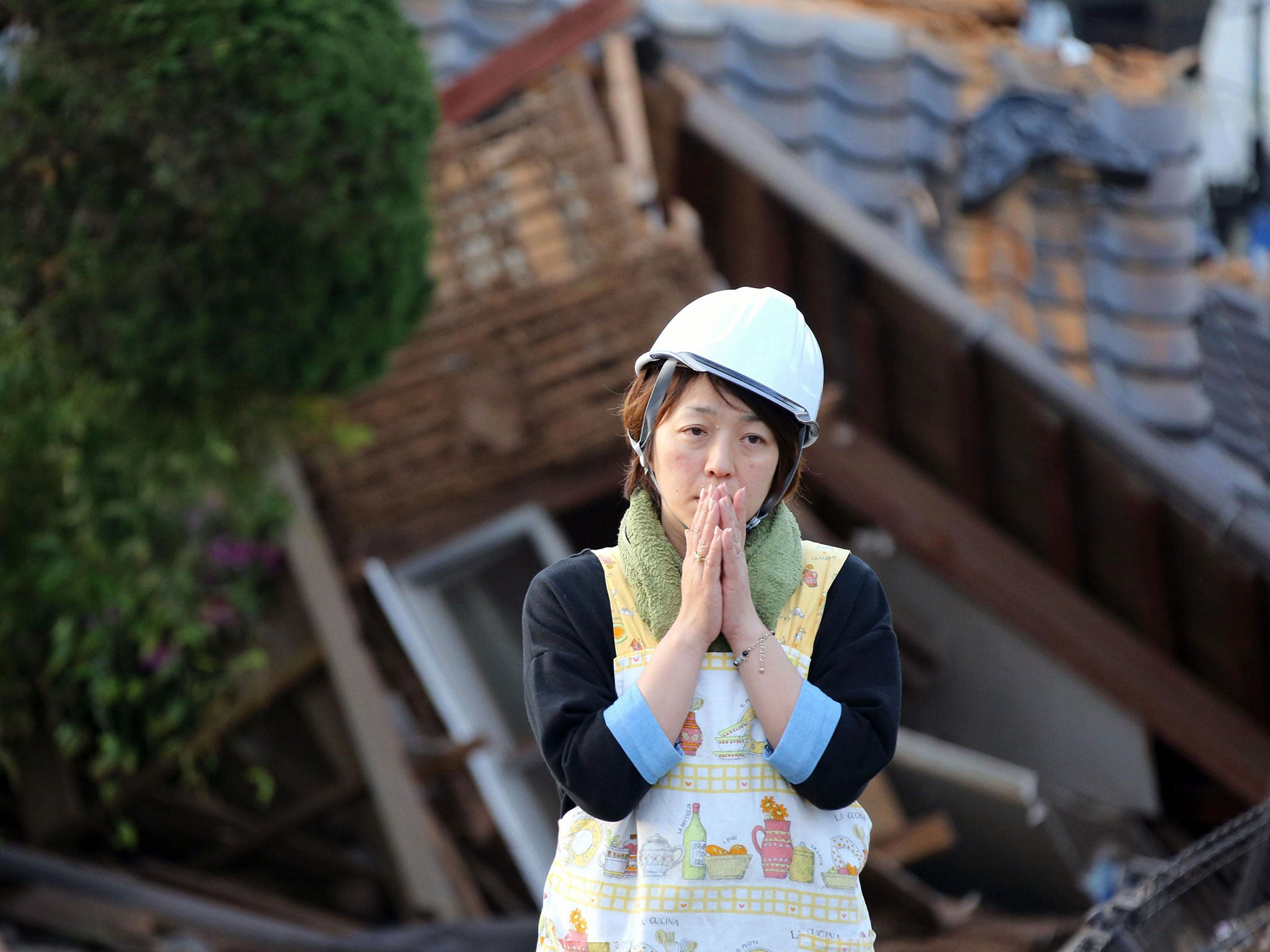 A resident stands in front of a damaged house in Mashiki, Kumamoto prefecture, southern Japan. The region has been hit by two powerful earthquakes in as many days.