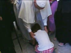 Refugee child prostrates herself at Pope Francis' feet during emotional tour of Greek island of Lesbos