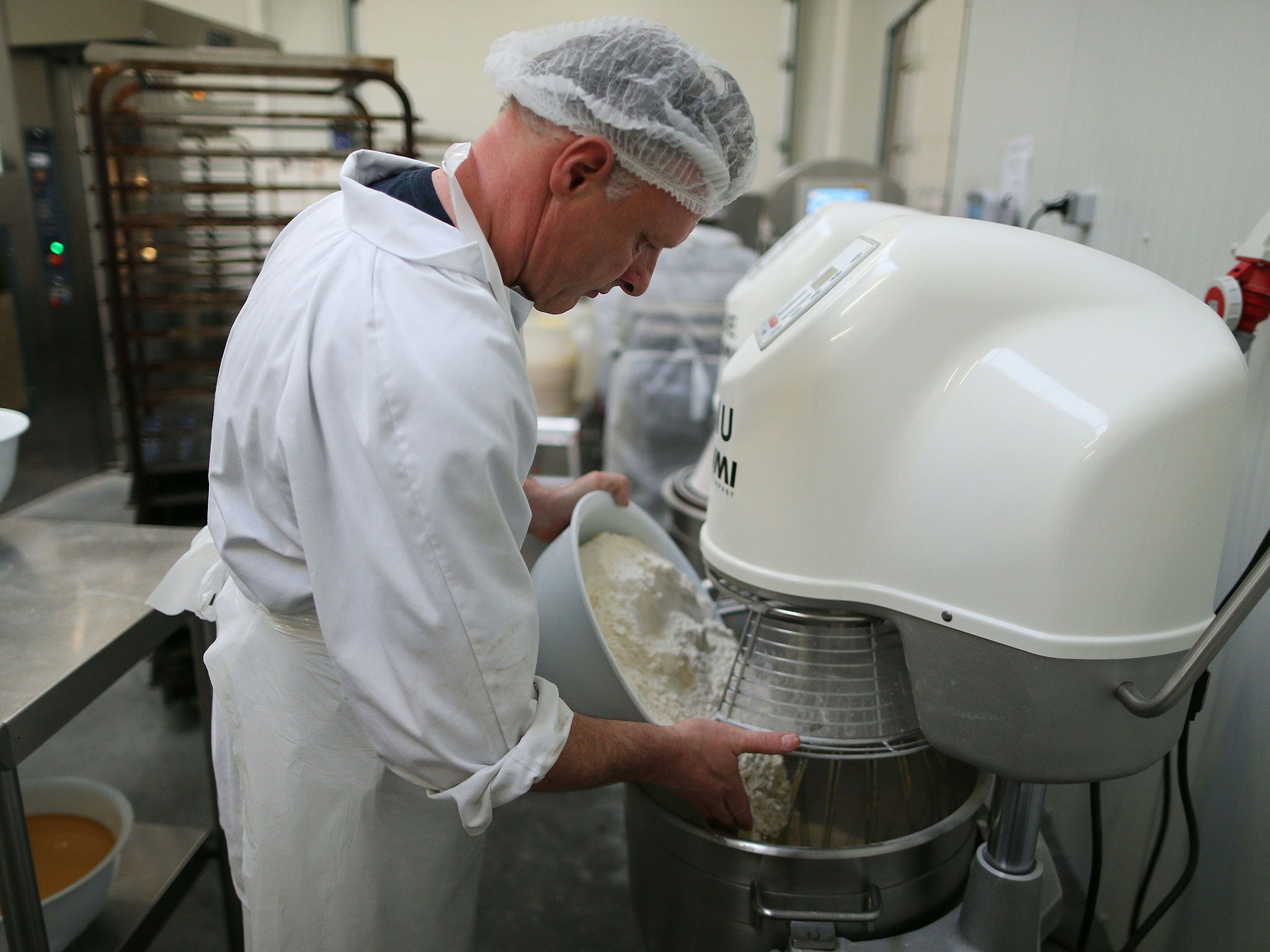 A Jeannette employee prepares the dough before the cooking of the madeleines in the production plant in Demouville on January 26, 2016