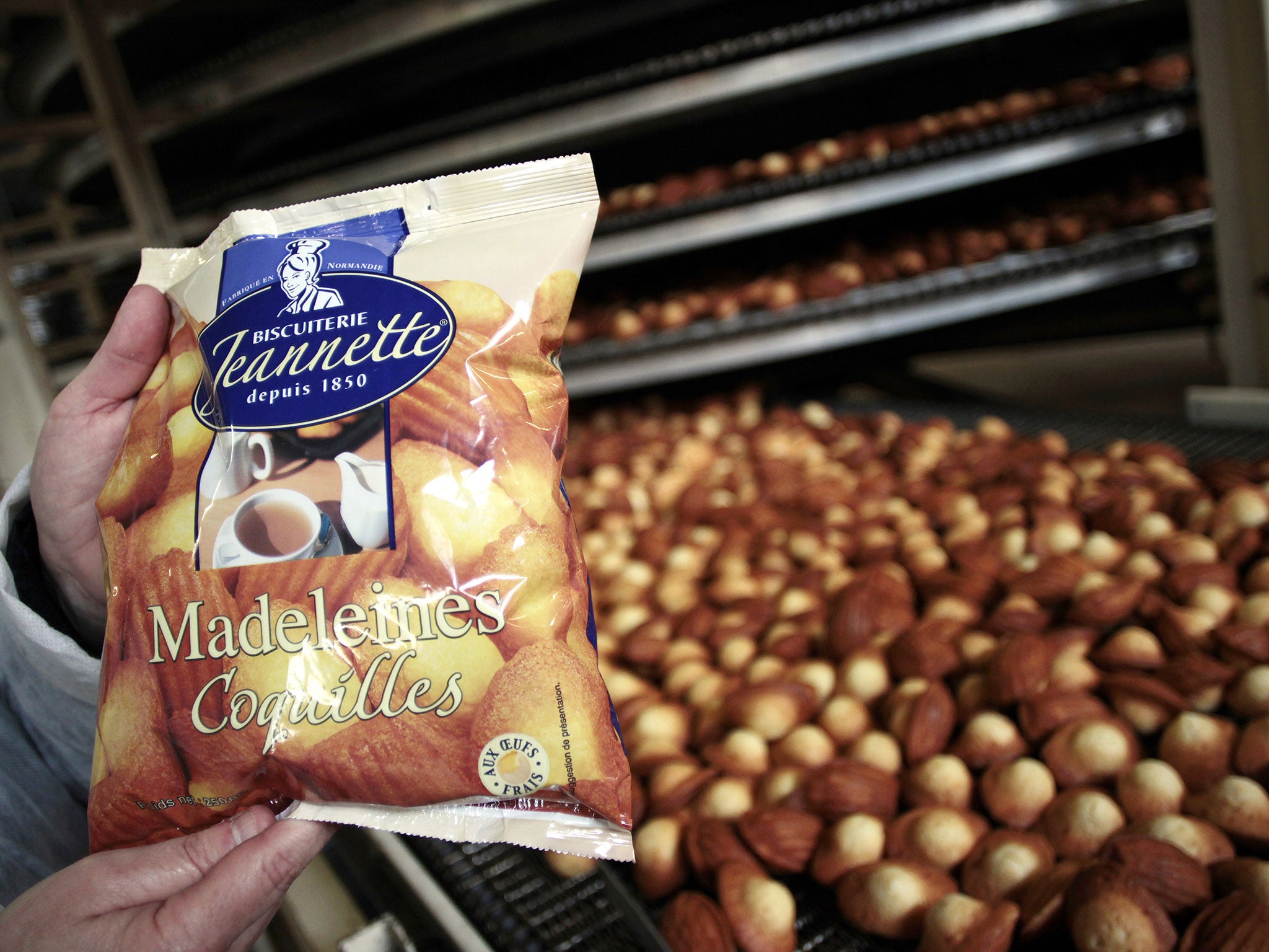 An employee of the Jeannette factory displays a packet as he supervises the production of madeleines as they occupy their plant, on March 19, 2013 in Caen, northwestern France.