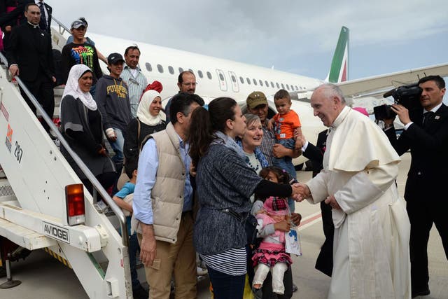 The Pope greets three refugee families who he invited to the Vatican