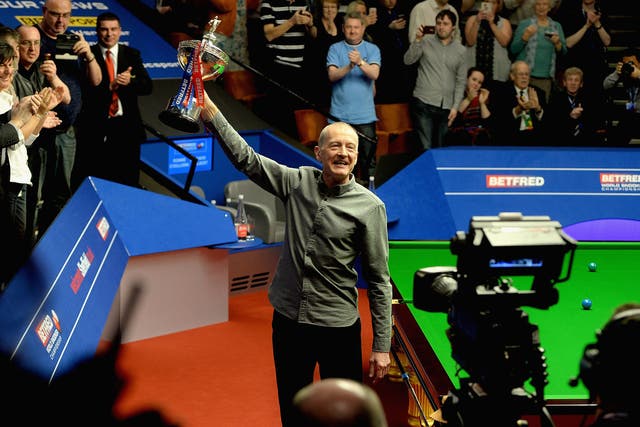 Former champion Steve Davis salutes the Crucible crowd with the World Snooker Championship trophy after announcing his retirement from the game