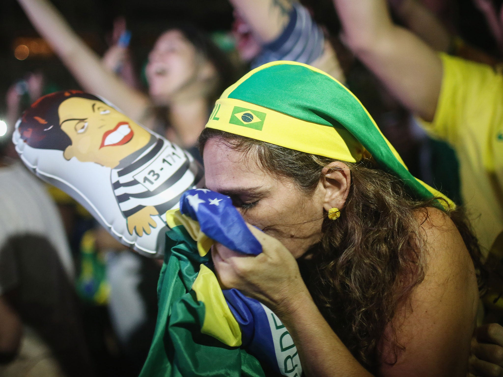 A pro-impeachment supporter kisses a Brazilian flag, as lower house deputies vote to approve the motion to continue the impeachment process of President Dilma Rousseff