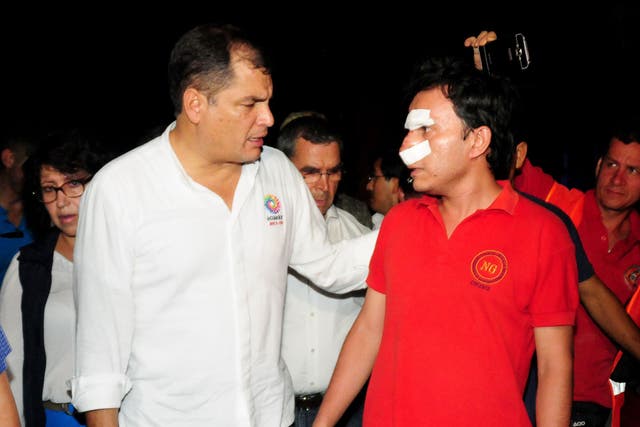 Ecuador's President Rafael Correa (L) talking to a wounded man during his visit to the city of Manta, Ecuador, on April 17, 2016 a day after a powerful 7.8-magnitude quake hit the country