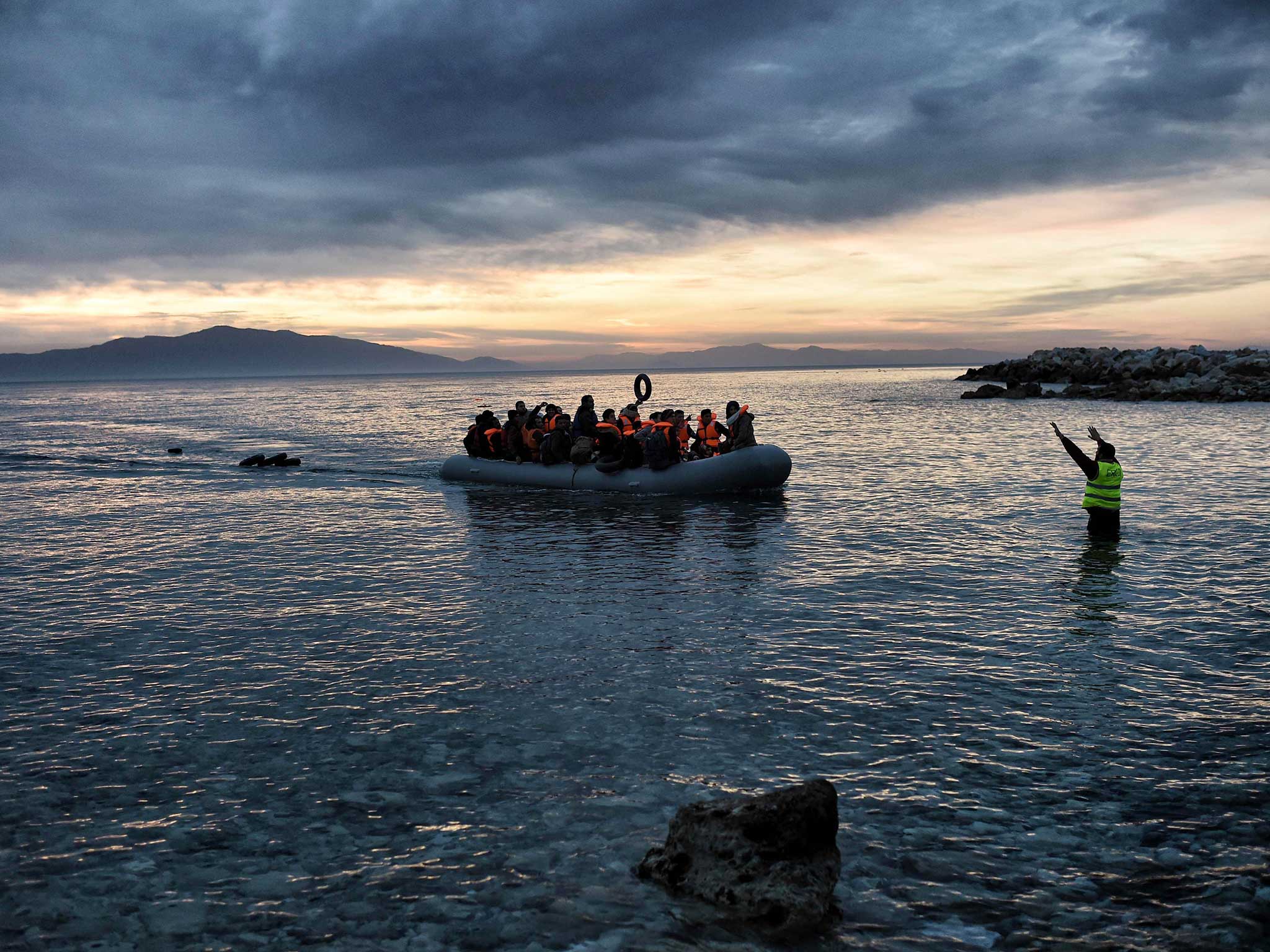 Refugees massed onto an inflatable boat reaching Mytilene, northern island of Lesbos, after crossing the Aegean sea from Turkey, on 17 February, 2016