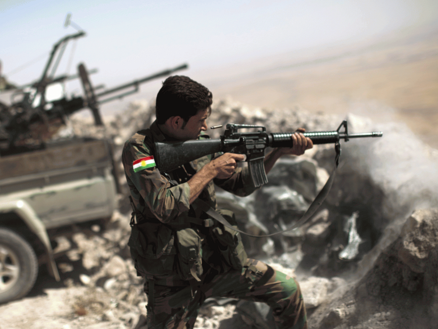 An Iraqi Kurdish peshmerga fighter fires on an Isis position JM LOPEZ/AFP/Getty Images