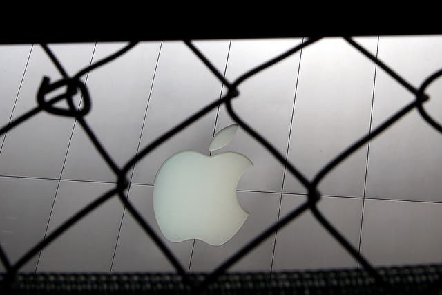 The Apple logo seen through a fence in San Francisco, California