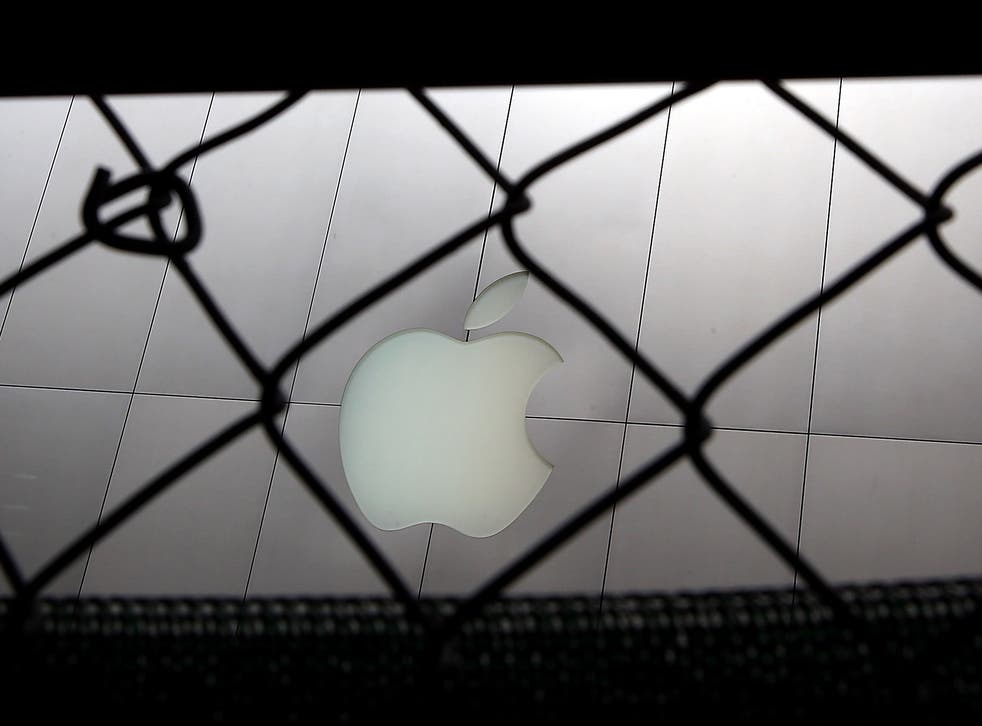 The Apple logo seen through a fence in San Francisco, California
