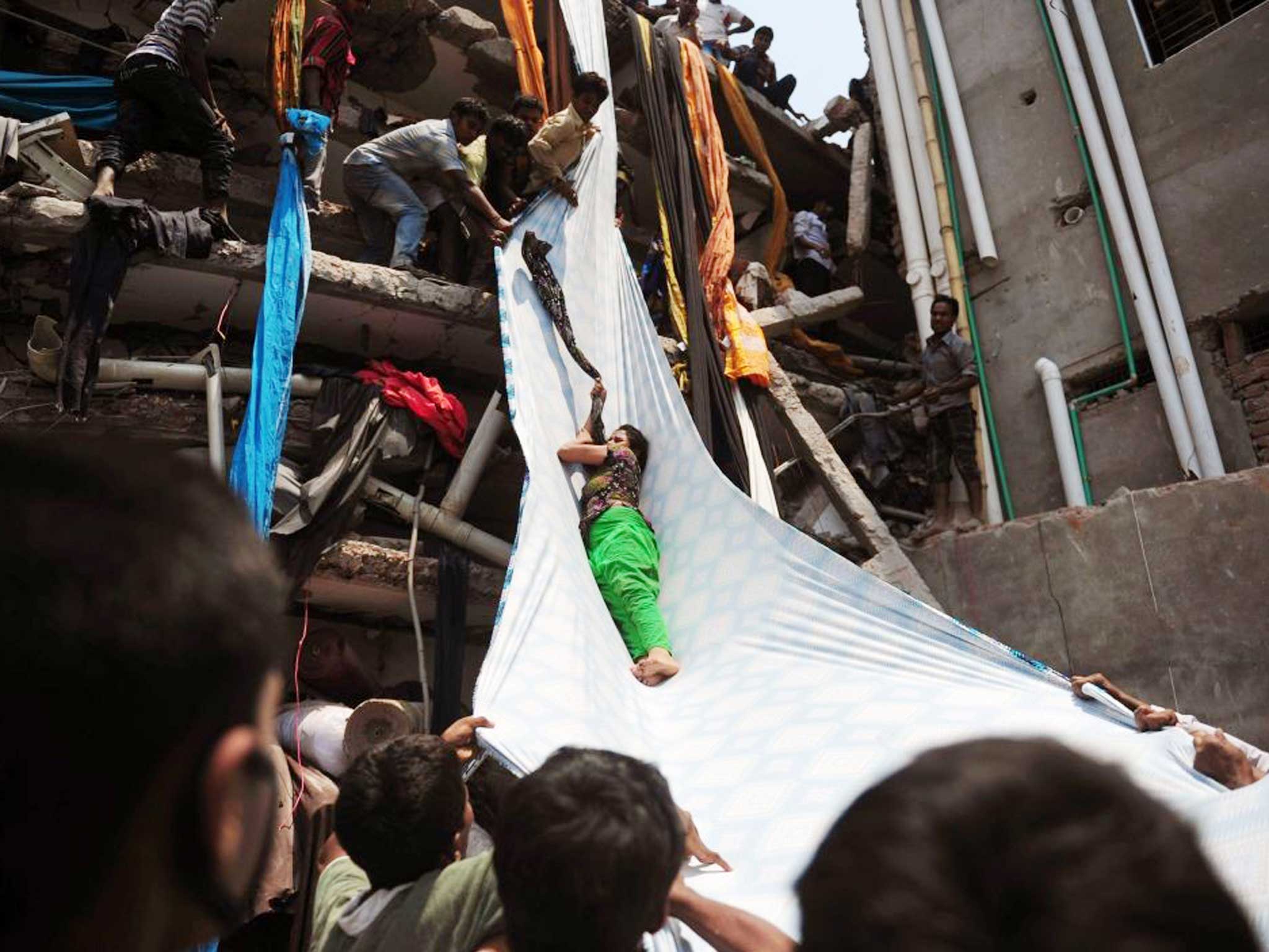 Garment workers evacuate a survivor after the Rana Plaza factory in Bangladesh collapsed in 2013