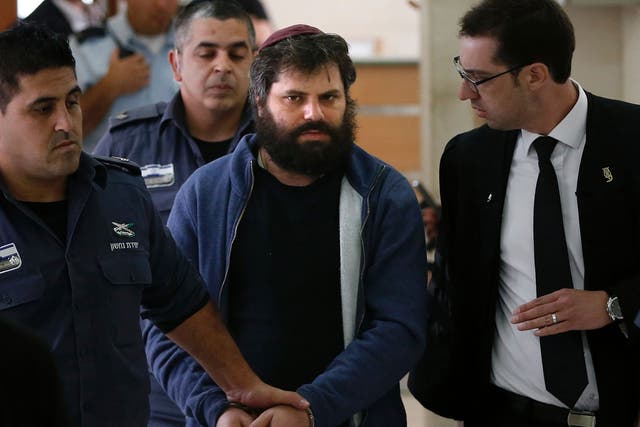 Israeli Yosef Haim Ben-David (C), the ringleader of the killing of Palestinian teenager Mohammed Abu Khdeir last year, is escorted by Israeli policemen at the district court in Jerusalem on April 19, 2016.