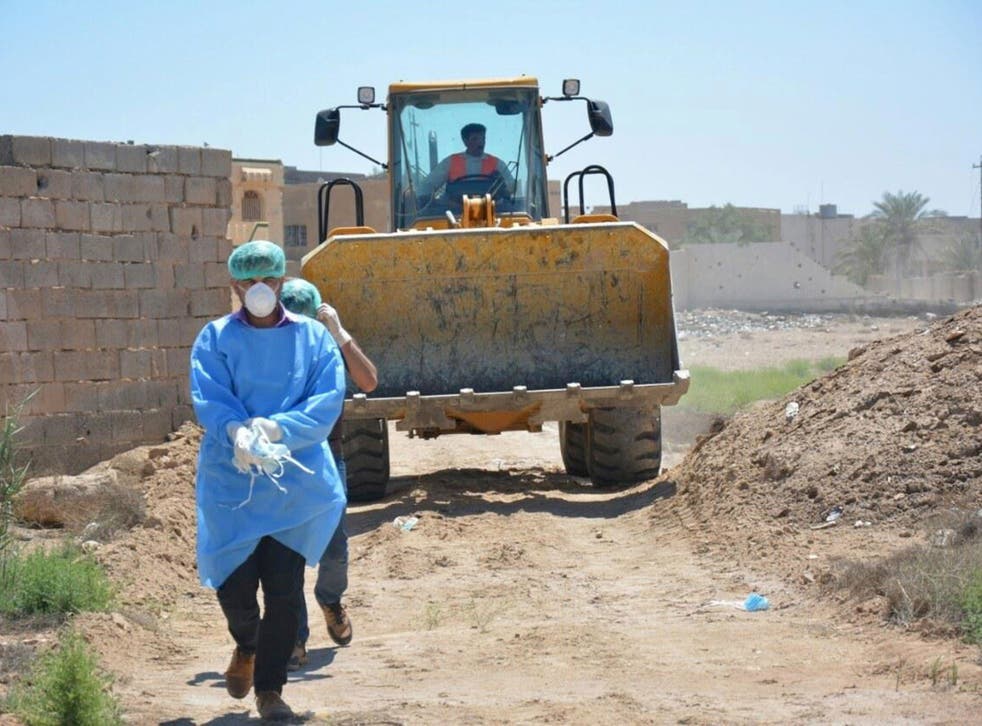 An Iraqi security forces forensic team works at at the site of a mass grave, one of two discovered containing the bodies of dozens of men, women and children killed by Isis militants in Ramadi