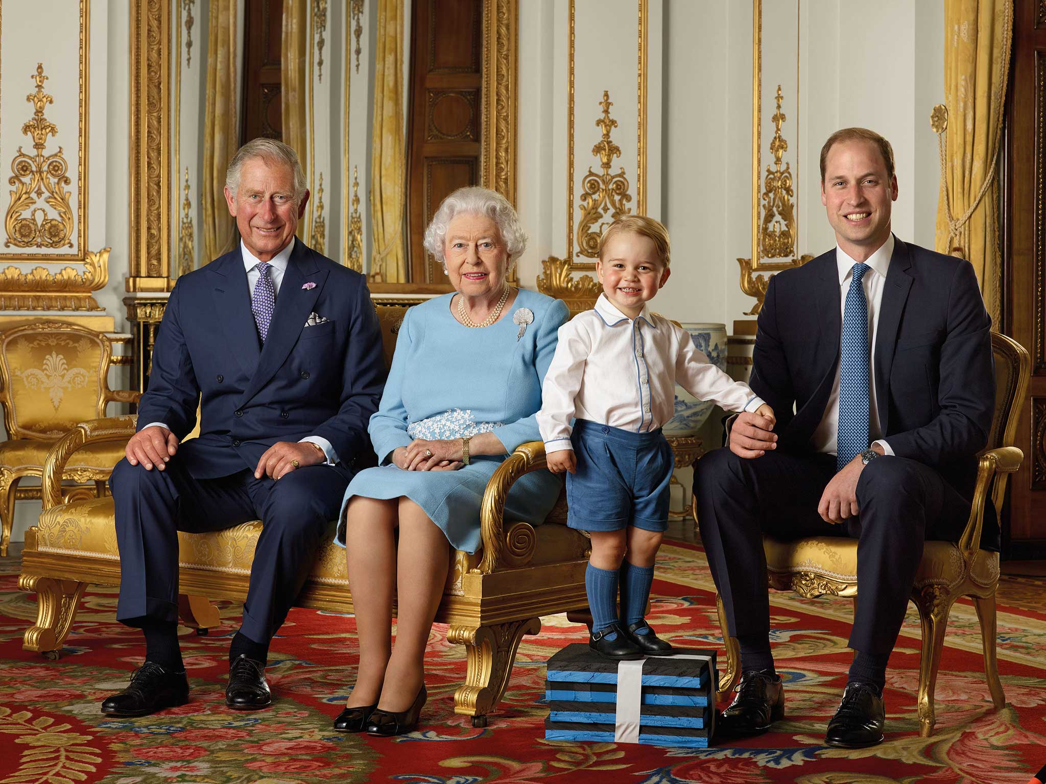 Prince George stands on foam blocks during a Royal Mail photoshoot for a stamp sheet to mark the 90th birthday of Queen Elizabeth II. The sheet features four generations of the Royal family, from left, the Prince of Wales, Queen Elizabeth II, Prince George and the Duke of Cambridge