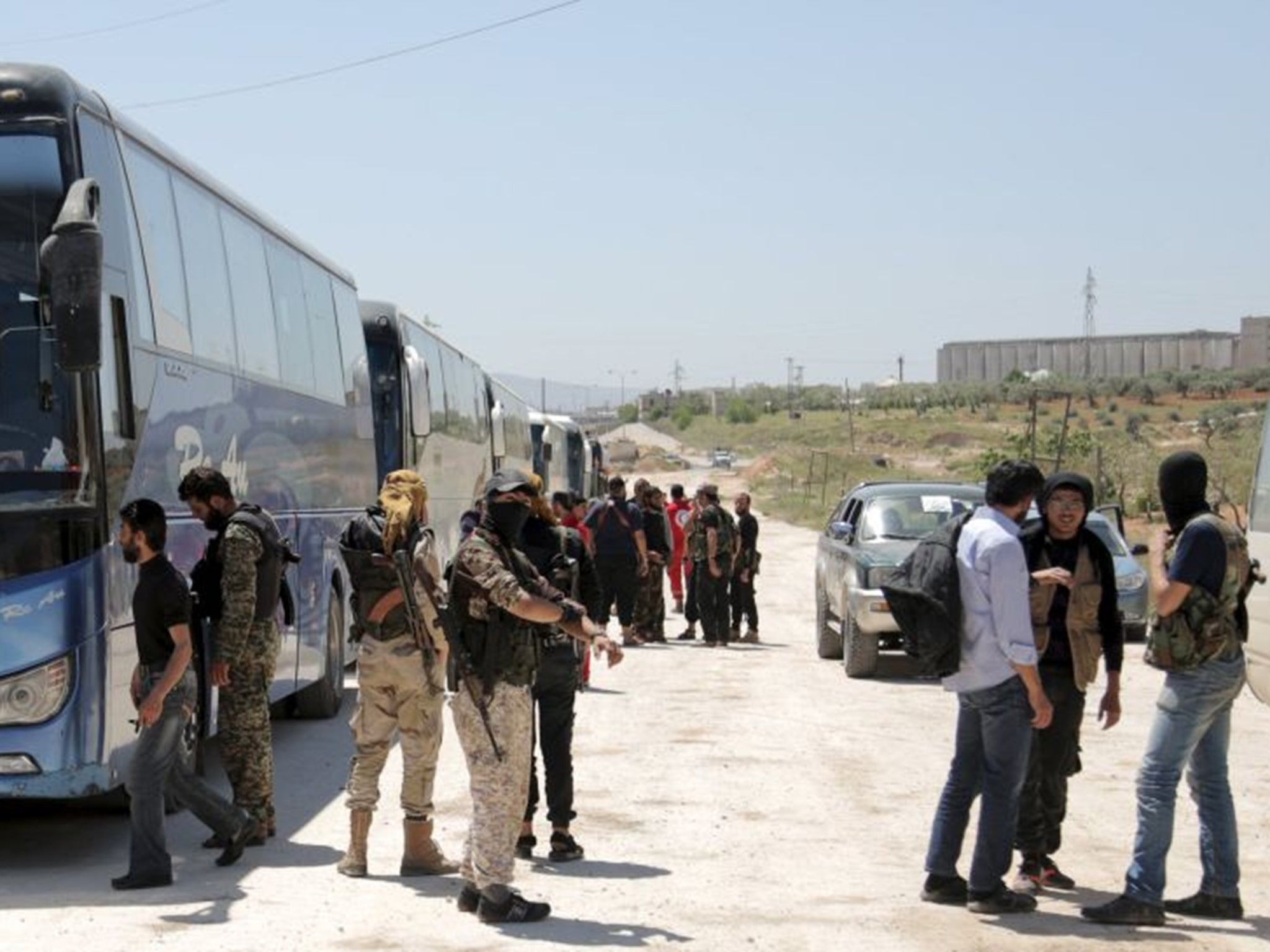 Buses line up on the outskirts of Idlib city, preparing to enter the besieged towns of Foah and Kefraya