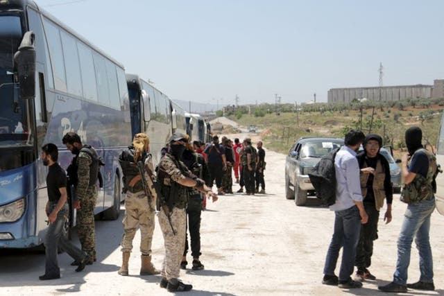 Buses line up on the outskirts of Idlib city, preparing to enter the besieged towns of Foah and Kefraya