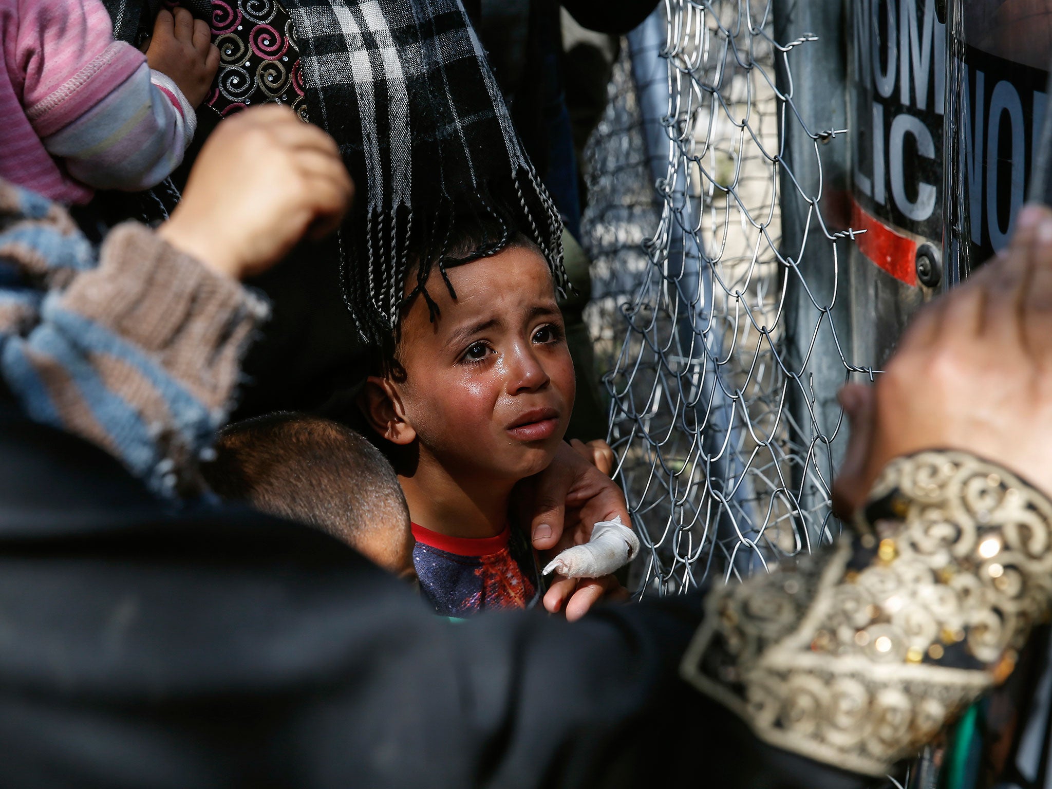 A child cries as migrants and refugees clash with Greek policemen as they try to open the border fence at a makeshift camp at the Greek-Macedonian border near the village of Idomeni, Greece, April 7, 2016