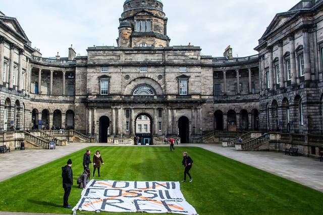 Some of the protesters lay out a banner at the university earlier this month