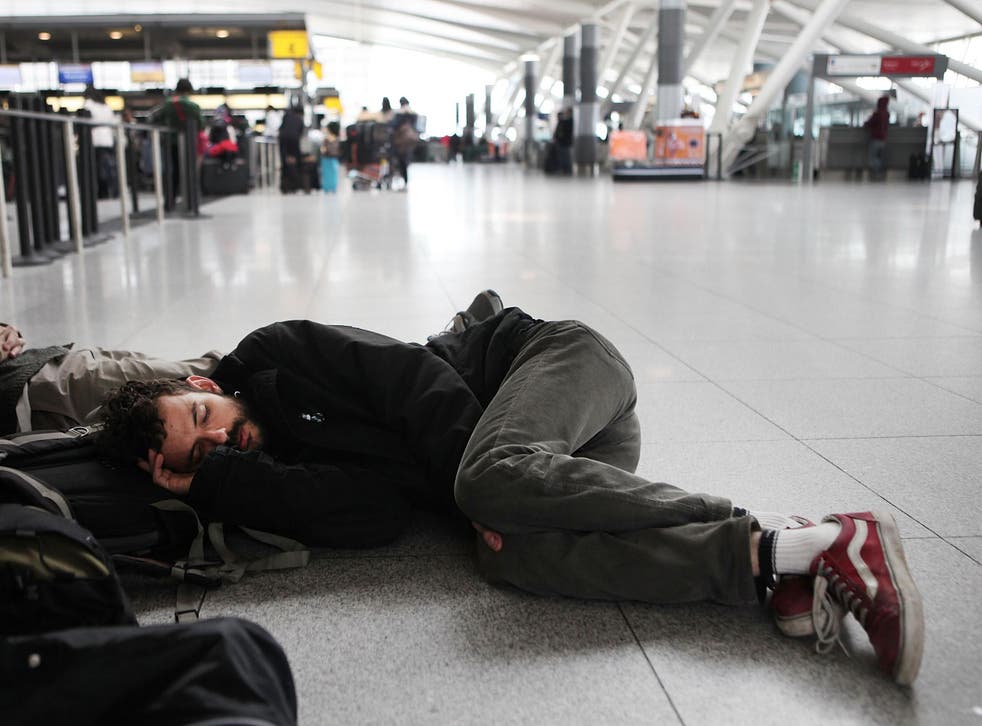 A man sleeps on the floor of JFK airport in New York after a storm delayed his flight