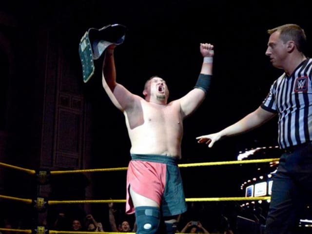 Samoa Joe lifts the NXT title after his victory over Finn Balor