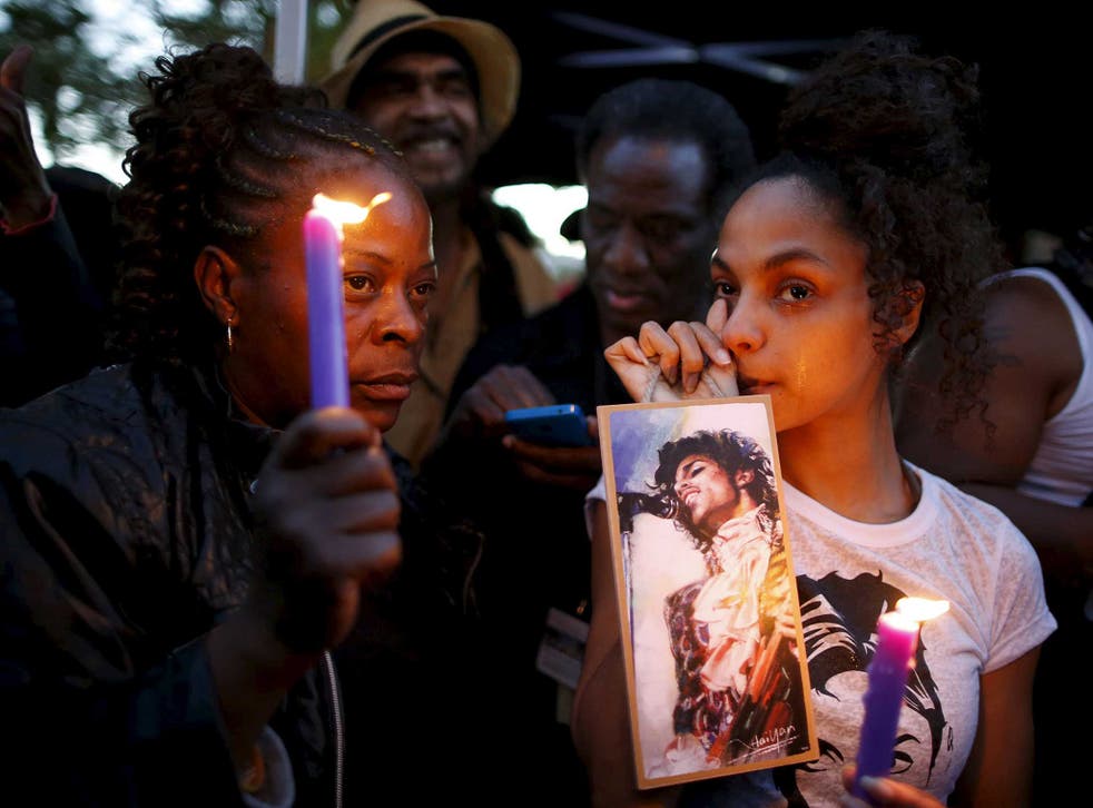Julya Baer, 30, (R) cries at a vigil to celebrate the life and music of deceased musician Prince in Los Angeles, California
