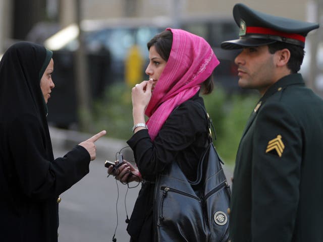 An Iranian policewoman (L) warns a woman about her clothing and hair during a crackdown to enforce Islamic dress code on April 22, 2007 in Tehran, Iran