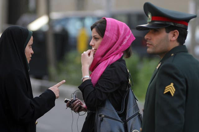 An Iranian policewoman (L) warns a woman about her clothing and hair during a crackdown to enforce Islamic dress code on April 22, 2007 in Tehran, Iran