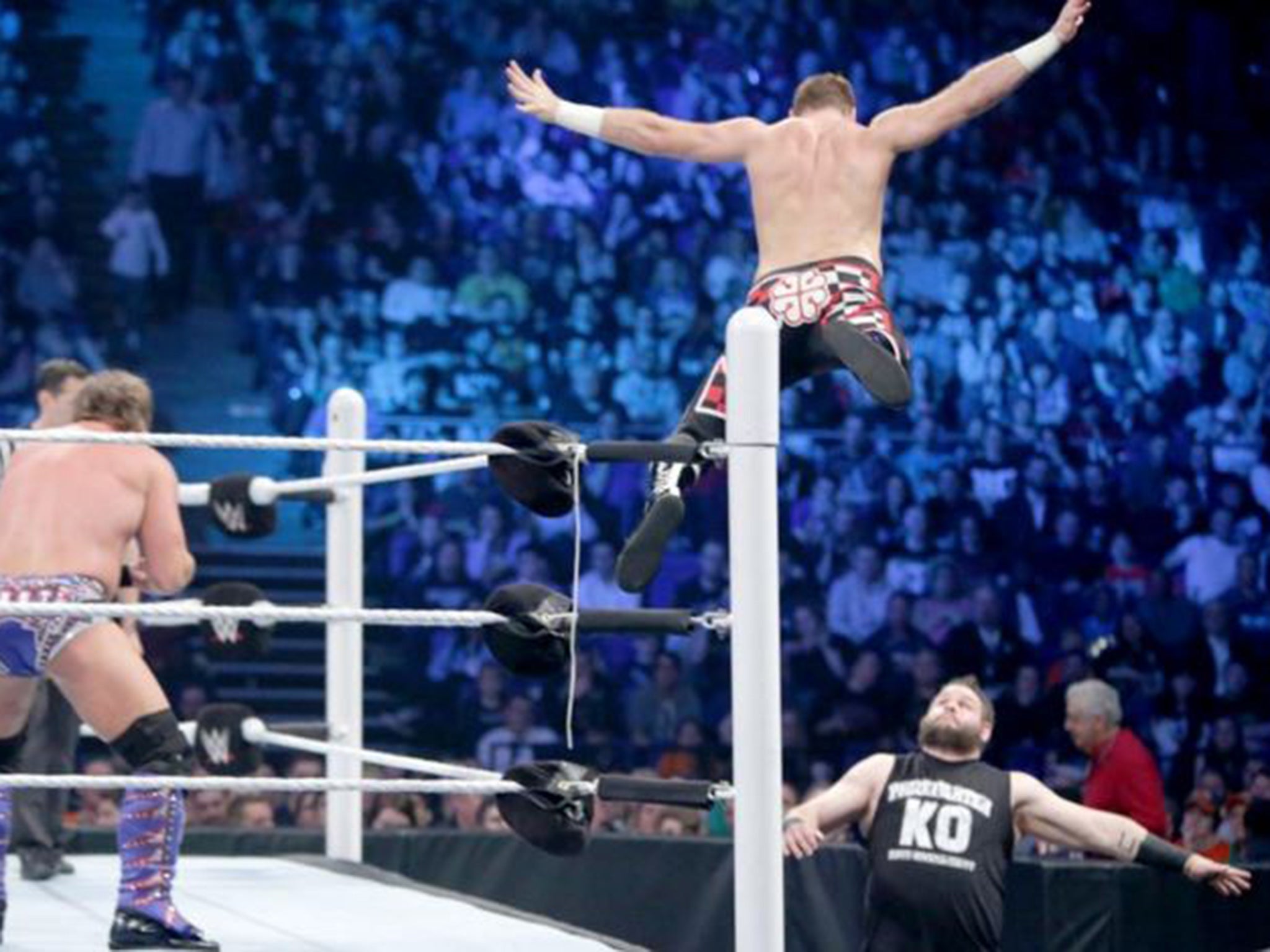 Sami Zayn leaps off the top rope to land on Kevin Owens