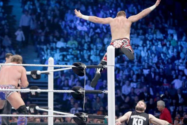 Sami Zayn leaps off the top rope to land on Kevin Owens