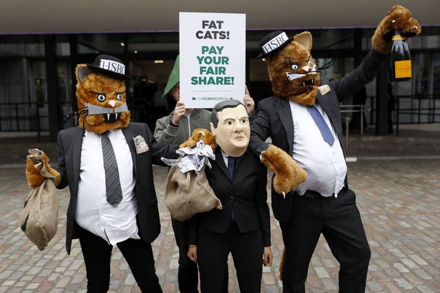 Robin Hood Tax campaigners dressed as fat cats and Britain's Chancellor of the Exchequer George Osborne outside the HSBC annual general meeting at the Queen Elizabeth II conference centre in London