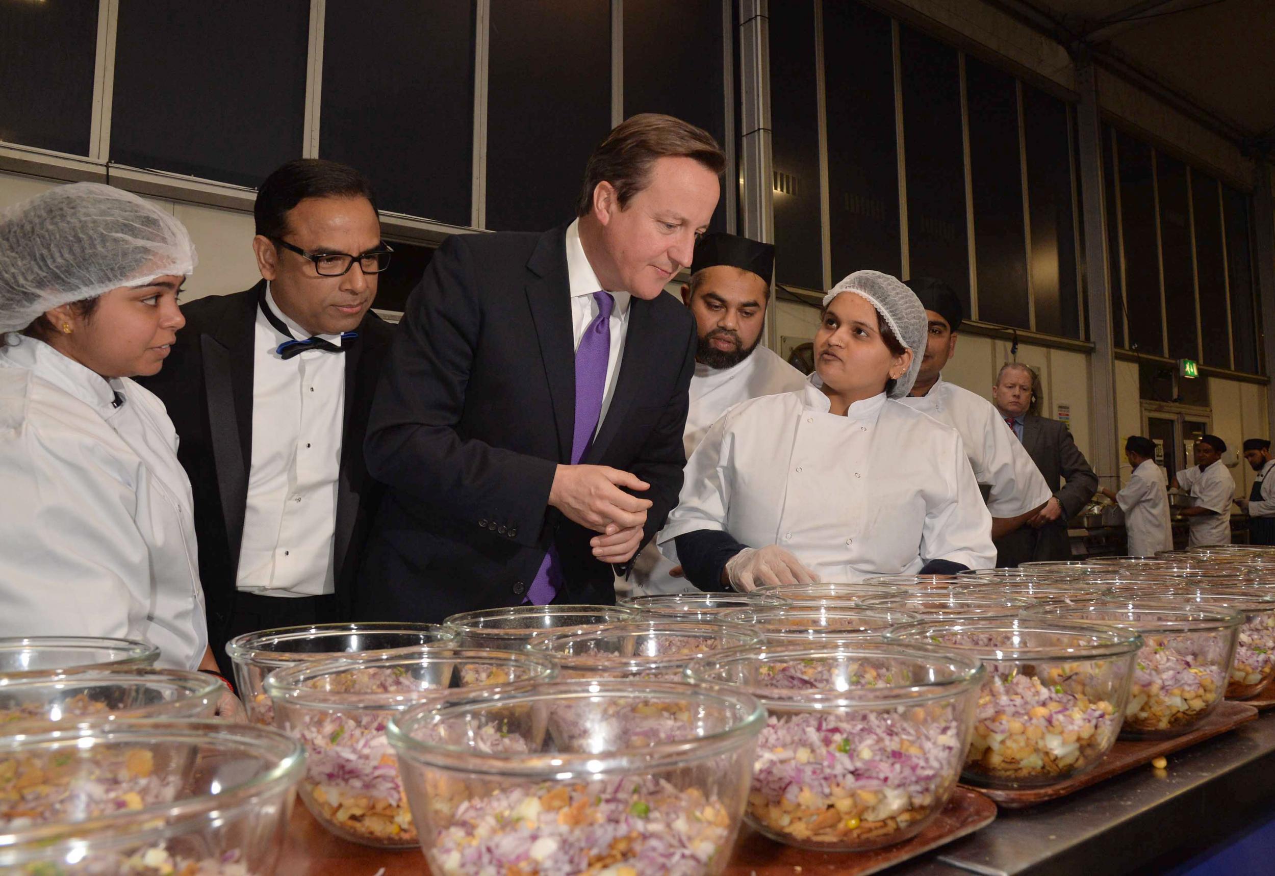 Curry Awards founder Enam Ali with Prime Minister David Cameron inspecting the winner's kitchen at the awards in 2013