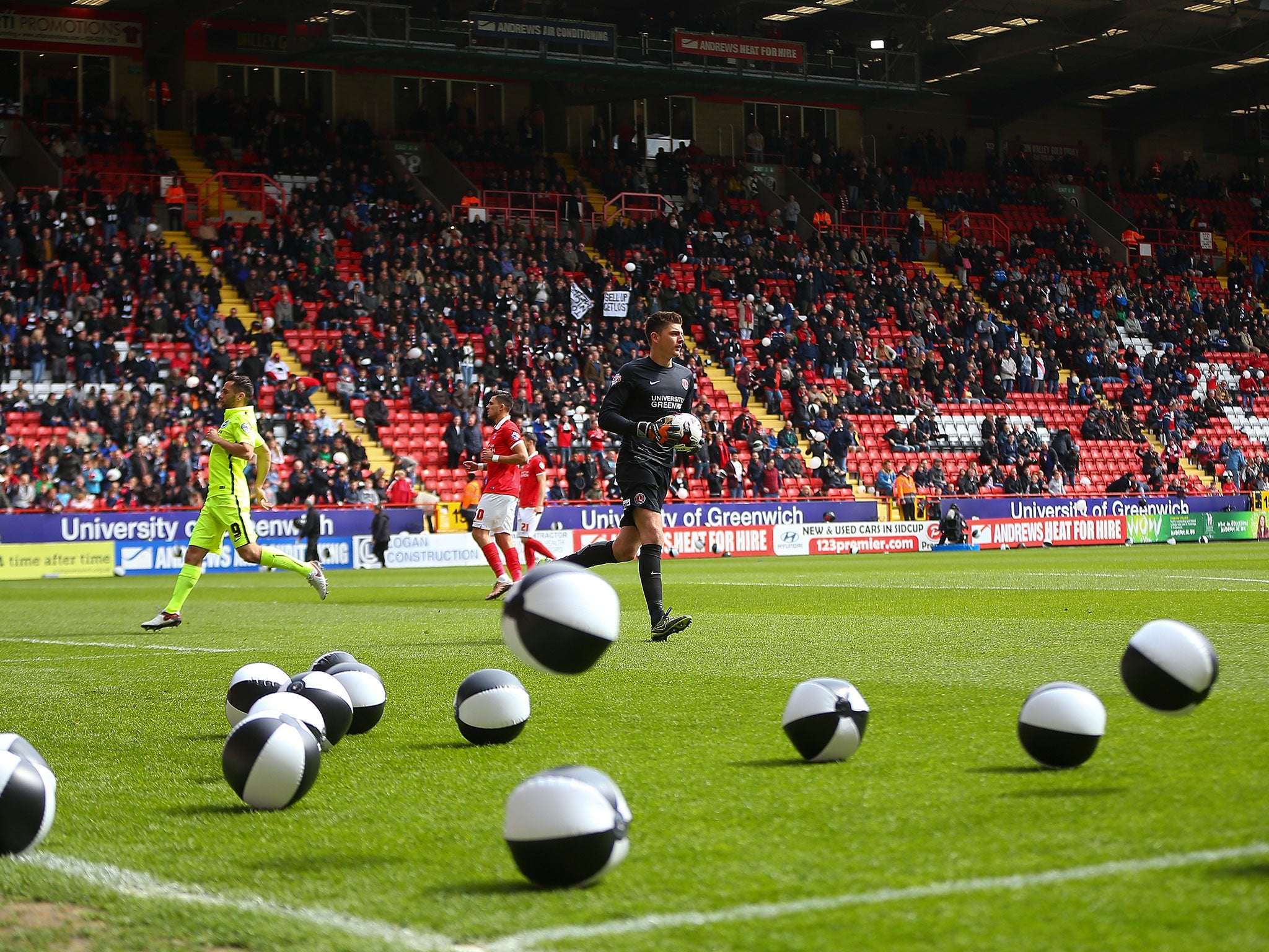 Charlton stewards clear beach balls from the pitch