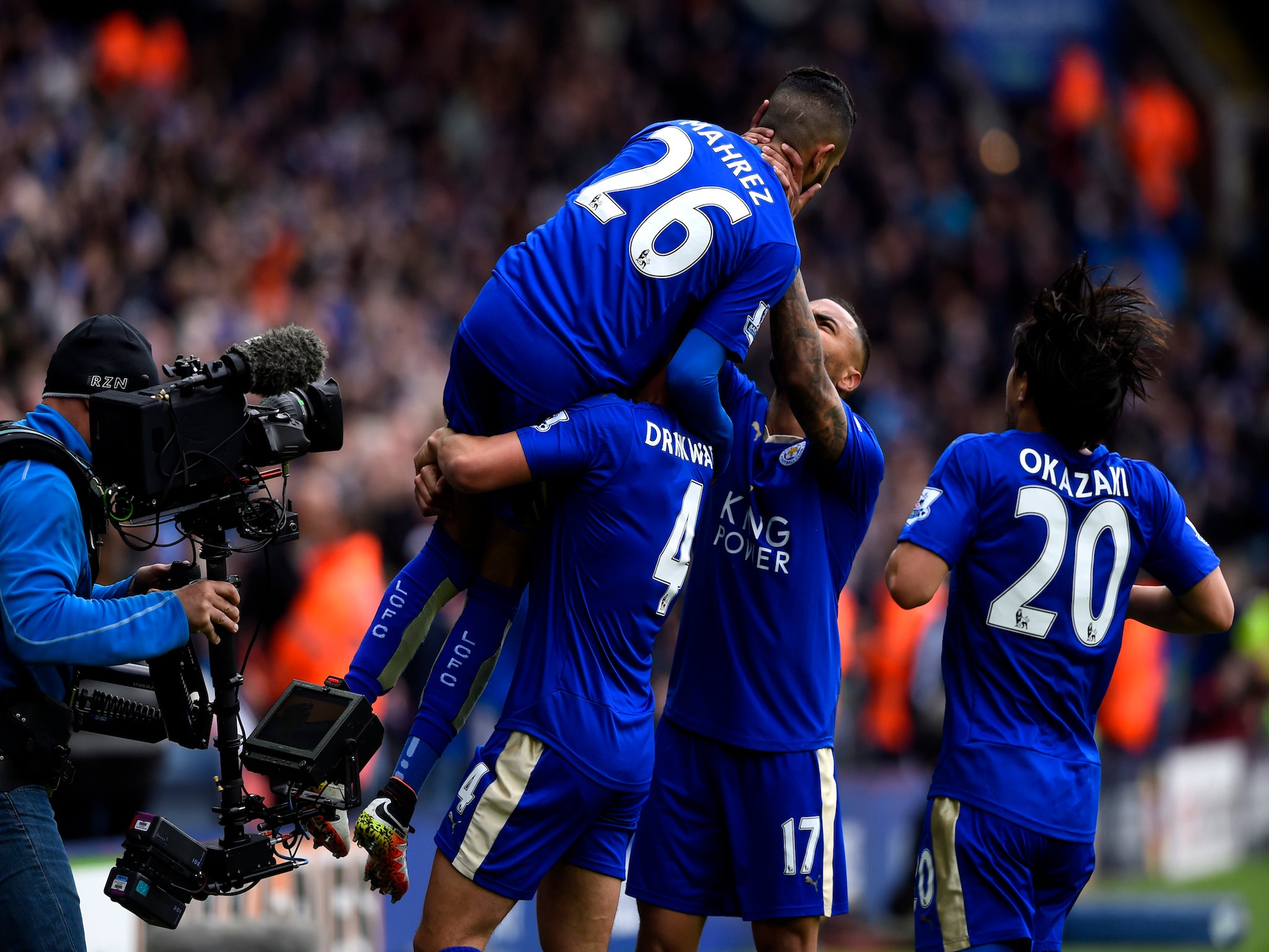 Riyad Mahrez is mobbed by his Leicester team-mates after scoring their opener against Swansea