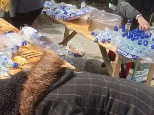 The alleged looters appear to fill bags and bin liners with the bottled water