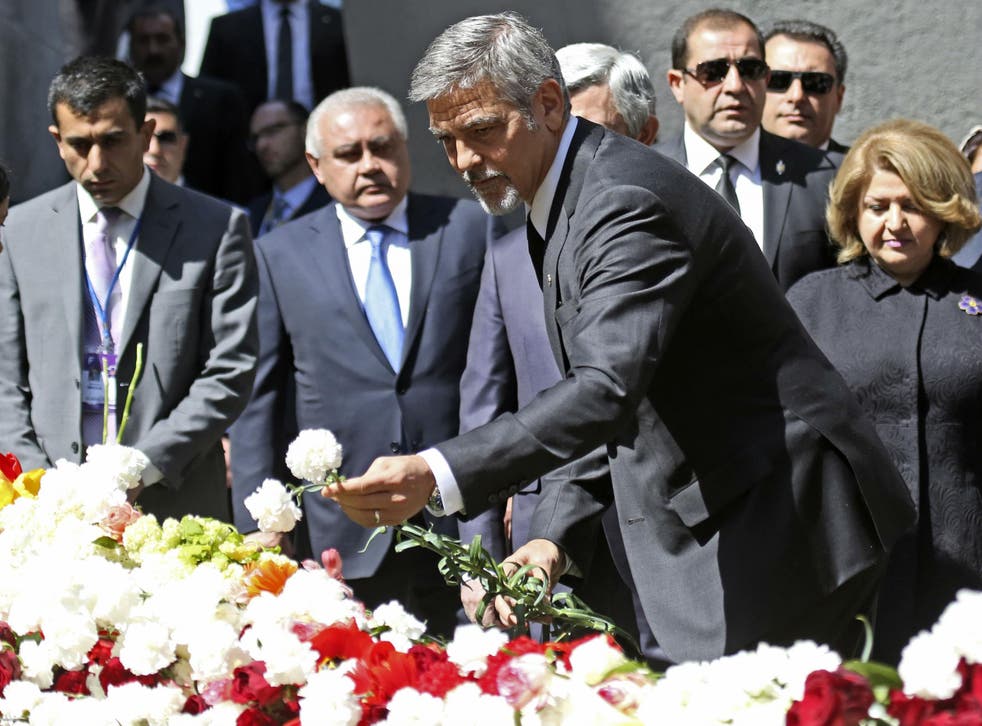 Mr Clooney laid a flower at the hilltop memorial