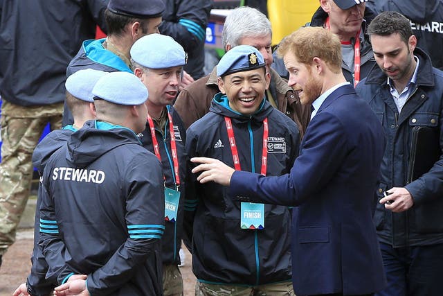 Prince Harry speaks with stewards during the 2016 Virgin Money London Marathon
