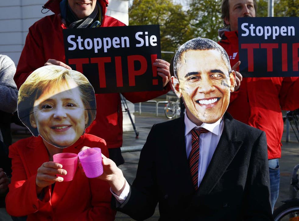 Protesters wear masks of U.S. President Barack Obama and German Chancellor Angela Merkel as they demonstrate against Transatlantic Trade and Investment Partnership (TTIP) free trade agreement before the opening ceremony of the Hannover Messe in Hanover, Germany April 24, 2016