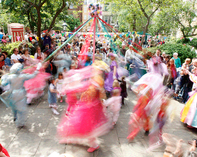 Children dressed as May Queens dance around a maypole in Covent Garden, London