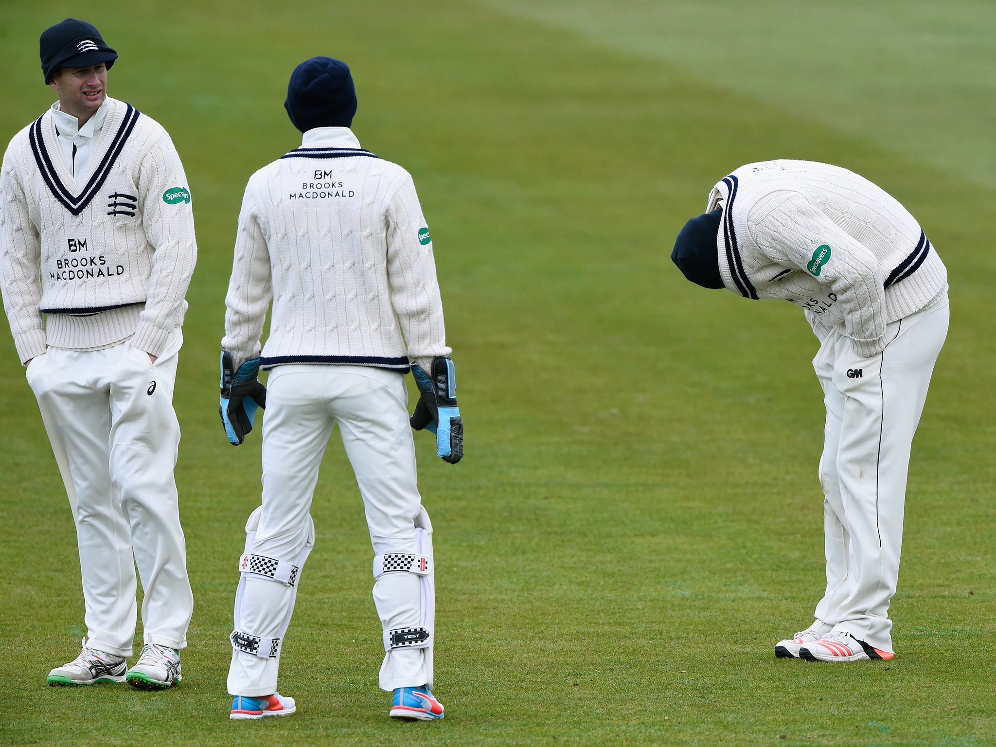 Middlesex fielder Dawid Malan (right) wicketkeeper John Simpson (centre) and captain Adam Voges don wooly hats in an attempt to keep warm