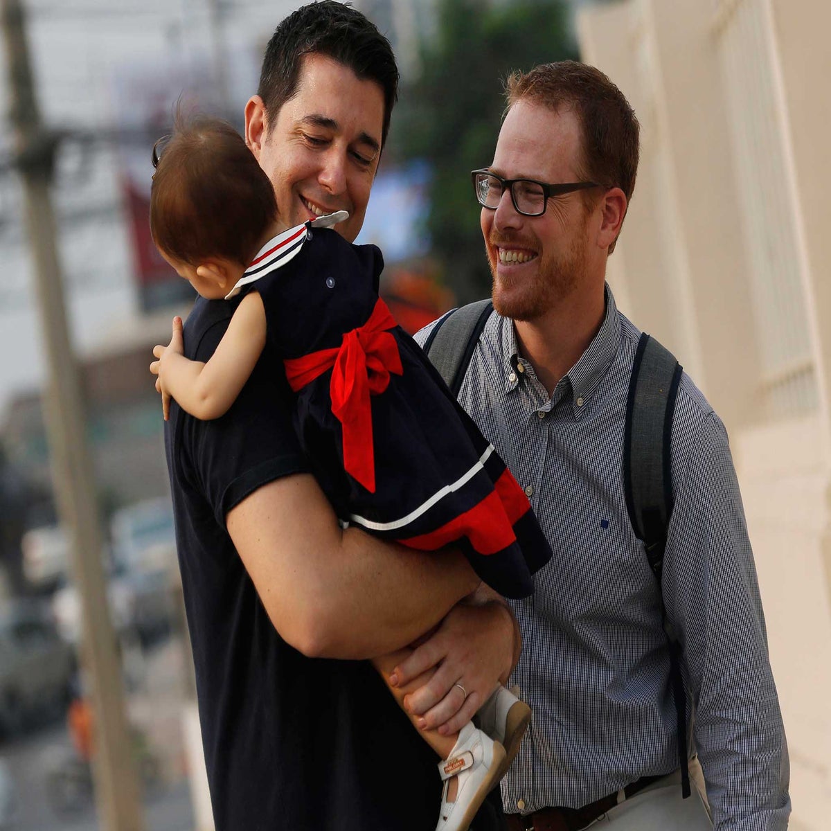 Gay couple sharing sweet moments with a surrogate mom. The young  fathers-to-be putting their