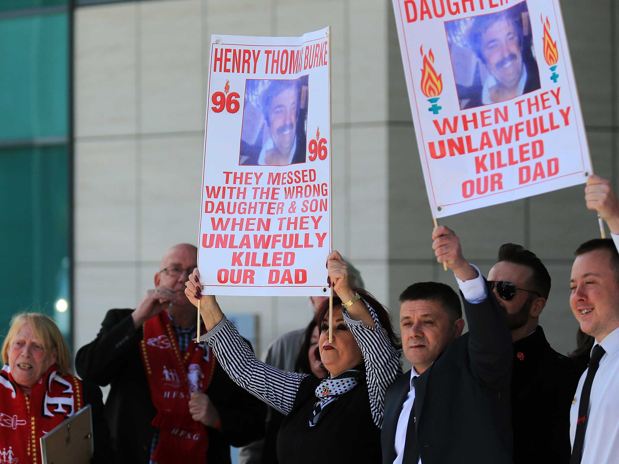 Relatives of Hillsborough victims hold up banners as they depart Birchwood Park after hearing the conclusions of the Hillsborough inquest