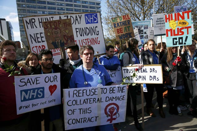 Junior doctors and supporters hold placards during a strike outside St Thomas' Hospital in London