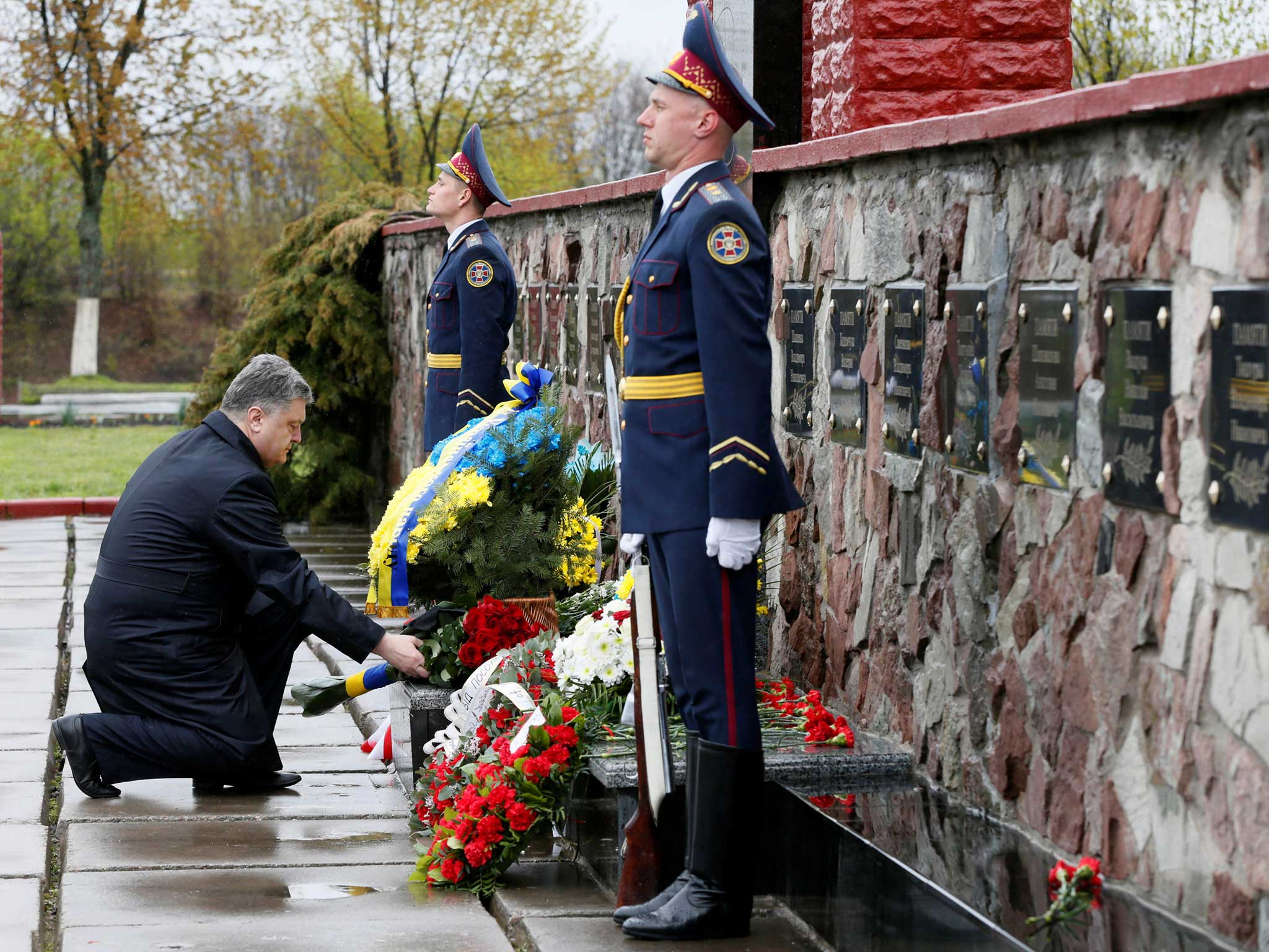 Ukrainian President Petro Poroshenko lays flowers during a commemoration ceremony at a monument to "liquidators", emergency workers who fought the blaze at the Chernobyl nuclear reactor, near the Chernobyl nuclear power plant