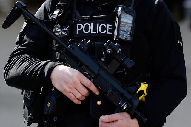 An armed British police officer holds his automatic weapon as he stands on duty in central London on March 22, 2016. B