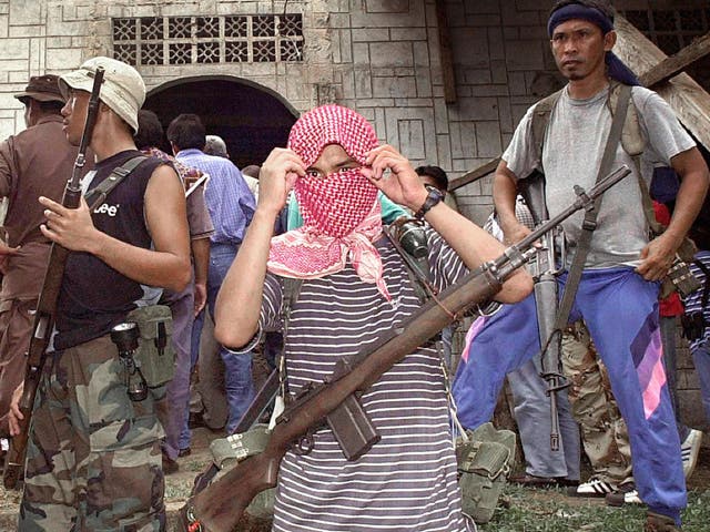 Photo taken 27 May, 2000, shows Muslim Abu Sayyaf rebels holding Western hostages taking position outside the mosque in their stronghold in Jolo island