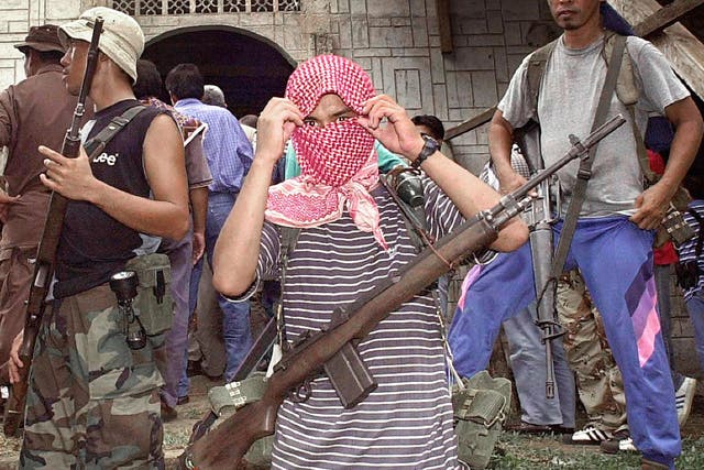 Photo taken 27 May, 2000, shows Muslim Abu Sayyaf rebels holding Western hostages taking position outside the mosque in their stronghold in Jolo island