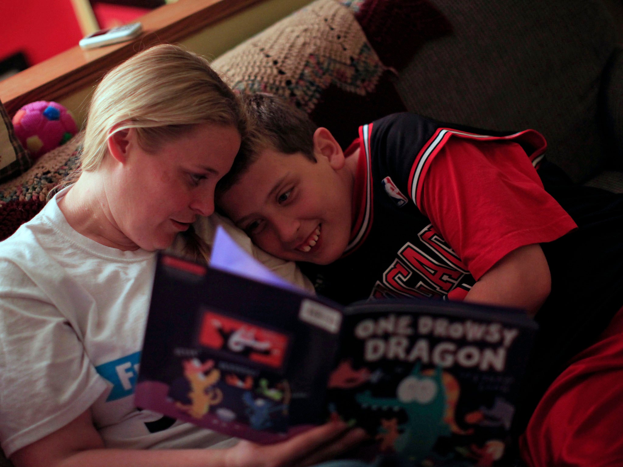 Holly Roos reads to her son Parker, who has Fragile X, at their home in Canton, Illinois