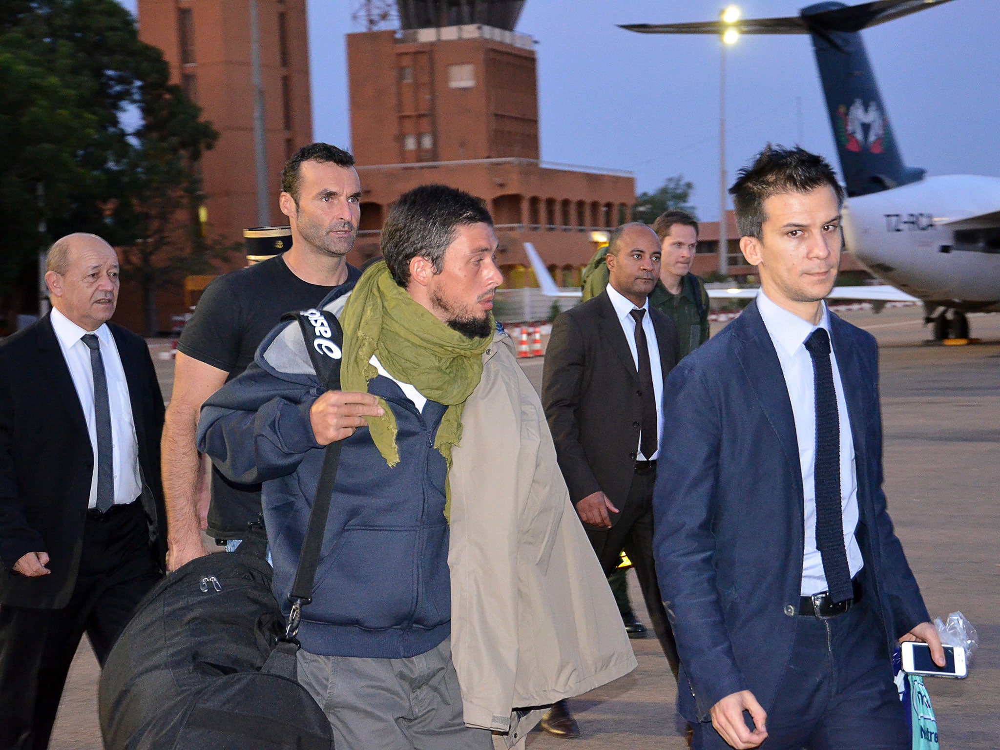 Former French hostage Pierre Legrand (centre) arrives at Niamey's airport with French Defence minister Jean-Yves Le Drian (left)