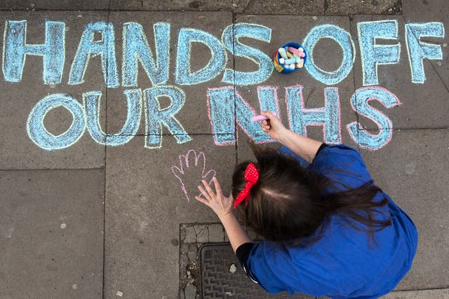 A junior doctor draws in chalk on the pavement outside King's College hospital in London
